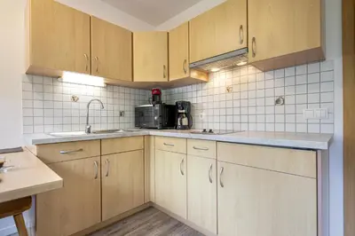 a kitchen with wooden cabinets and a sink at Apartments Woerndle in Siusi