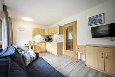 a living room with a couch and a kitchen at Apartments Woerndle in Siusi
