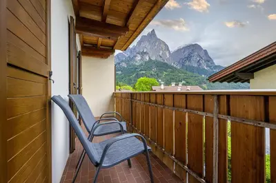 two chairs on a balcony with a view of mountains at Apartments Woerndle in Siusi