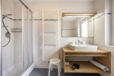 a bathroom with a sink and a shower and a mirror at Apartments Woerndle in Siusi