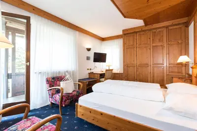 a bedroom with a bed and a desk and a tv at Residence MAYR in Castelrotto