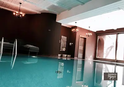 a swimming pool in a room with a pool at Residence MAYR in Castelrotto