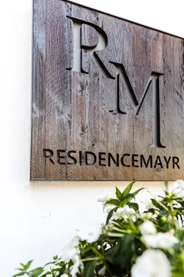 a sign on the side of a house that reads rwxresresiversary at Residence MAYR in Castelrotto
