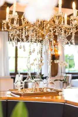 a chandelier with wine glasses on a table at Residence MAYR in Castelrotto
