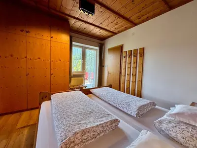 a bedroom with two beds and a window at Residence Linde - Ferienwohnungen & Apartments in Castelrotto