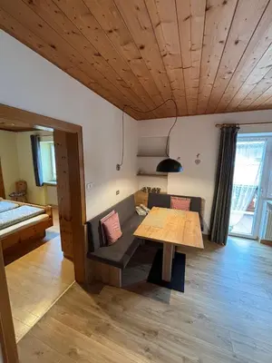 a living room with a table and a couch at Residence Linde - Ferienwohnungen & Apartments in Castelrotto
