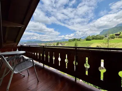 a balcony with a table and a chair and a view at Residence Linde - Ferienwohnungen & Apartments in Castelrotto