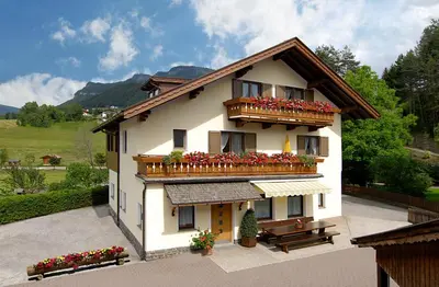 a building with a balcony with flowers on it at Residence Linde - Ferienwohnungen & Apartments in Castelrotto