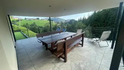 a patio with a wooden table and chairs on a balcony at Appartement Bachguter in Avelengo
