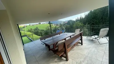 a large balcony with a wooden table and chairs at Appartement Bachguter in Avelengo
