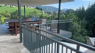 a balcony with a wooden table and bench on it at Appartement Bachguter in Avelengo
