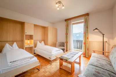 a hotel room with two beds and a window at Garni-Residence Villa Paul in Nova Ponente