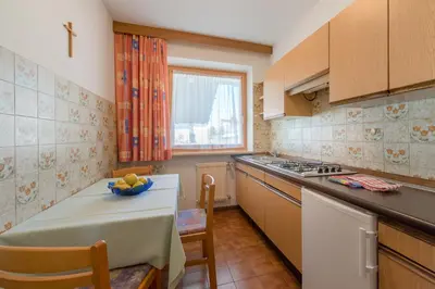 a kitchen with a table and a counter top at Garni-Residence Villa Paul in Nova Ponente