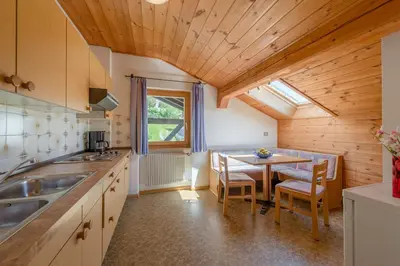 a kitchen with a table and a dining room at Garni-Residence Villa Paul in Nova Ponente