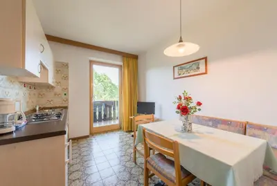 a kitchen with a table with a vase of flowers on it at Garni-Residence Villa Paul in Nova Ponente