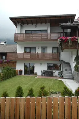 a house with a fence in front of a yard at Appartement Fischnaller in Mühlbach