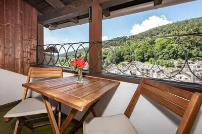 a table and chairs on a balcony with a view at Hotel Weisse Lilie - B&B in Mühlbach
