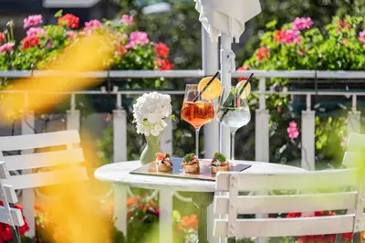 a table with a plate of food and a glass of wine at Hotel Weisse Lilie - B&B in Mühlbach