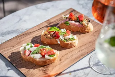 three sandwiches on a wooden cutting board on a table at Hotel Weisse Lilie - B&B in Mühlbach