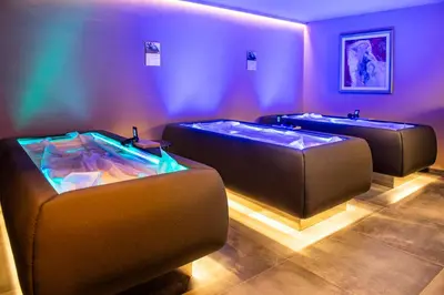 a bathroom with a bath tub and a sink at Hotel Montchalet in Ortisei