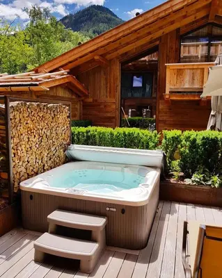 a hot tub on the deck of a house at Hotel Montchalet in Ortisei