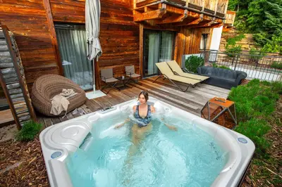 a woman in a hot tub in a backyard at Hotel Montchalet in Ortisei