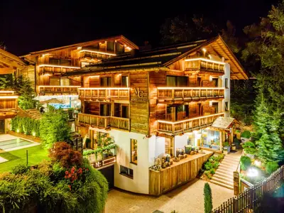a house with lights on it at night at Hotel Montchalet in Ortisei