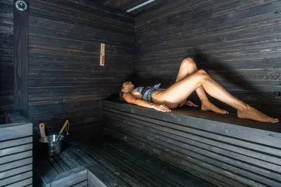 a man is laying in a sauna at Hotel Montchalet in Ortisei