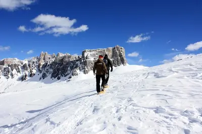 two people walking up a snow covered mountain at Villa Cristallino -Stayincortina in Cortina dʼAmpezzo