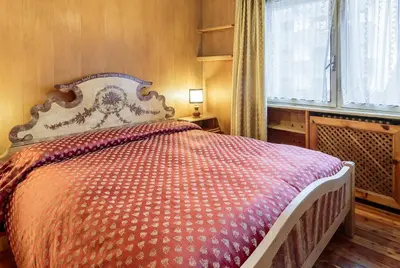 a bedroom with a bed with an orange and white comforter at Villa Cristallino -Stayincortina in Cortina dʼAmpezzo