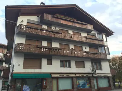 a tall building with a balcony on top of it at Villa Cristallino -Stayincortina in Cortina dʼAmpezzo