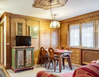 a dining room with a table and chairs and a tv at Villa Cristallino -Stayincortina in Cortina dʼAmpezzo
