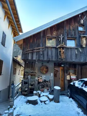 a wooden building with a car parked in front of it at Cianbolpin Guesthouse in Canazei