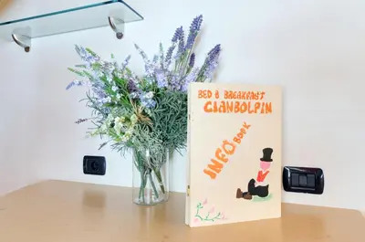 a vase of flowers sitting on a table next to a book at Cianbolpin Guesthouse in Canazei