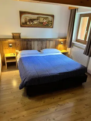 a bedroom with a bed with a blue comforter at Garni Eden Bed and breakfast in Soraga
