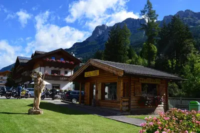 a wooden building with a mountain in the background at Garni Eden Bed and breakfast in Soraga
