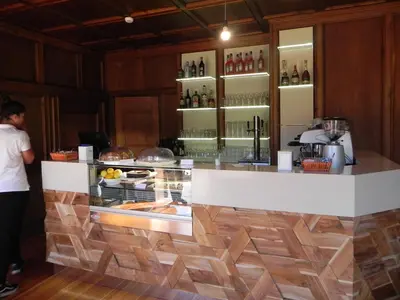 a man standing in front of a counter in a restaurant at Dolomiti Sport Hotel in San Vito di Cadore