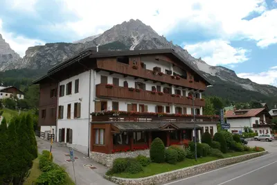 a building on the side of a street with a mountain at Dolomiti Sport Hotel in San Vito di Cadore