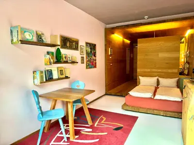 a small room with a table and a bed at DESIGN APARTMENTS living Kampill in Bolzano