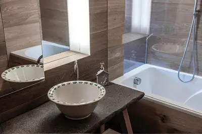 a bathroom with a bowl sink and a tub at DESIGN APARTMENTS living Kampill in Bolzano