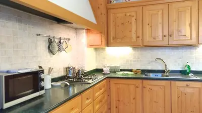 a kitchen with a table and a television in it at Casa Rossi in Le Grazie