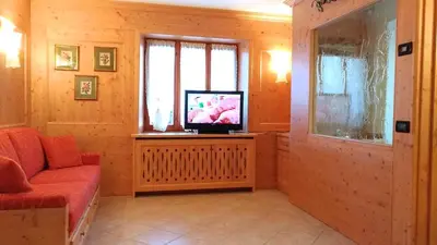 a living room with a couch and a television at Casa Rossi in Le Grazie