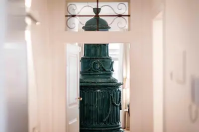 a green vase sitting on a table next to a door at Stay COOPER l Laubenhaus in Bolzano
