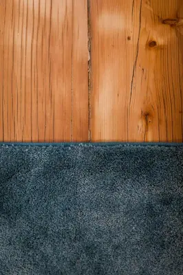 a wooden floor with a blue rug next to a wooden wall at Stay COOPER l Laubenhaus in Bolzano
