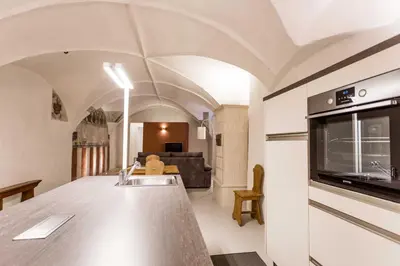 a kitchen and living room with a counter and a sink at Stay COOPER l Laubenhaus in Bolzano
