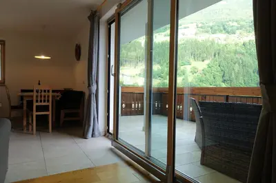 a room with a view of a balcony with a table at Privatpension Bergkristall in San Martino