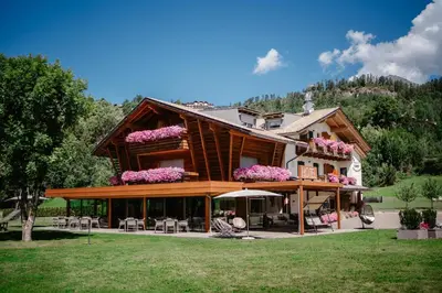 a house with flowers on the top of it at Albergo Garnì Antico Mas del Medico in Cavalese