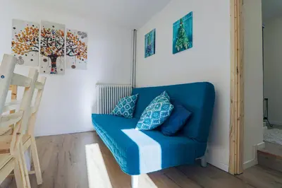 a blue couch in a room with paintings on the wall at Una Civetta sul Lago in Alleghe