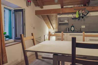 a kitchen and dining room with a table and chairs at Una Civetta sul Lago in Alleghe