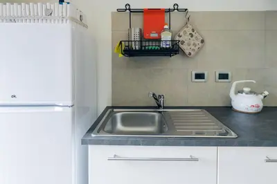 a kitchen with a sink and a refrigerator at Una Civetta sul Lago in Alleghe